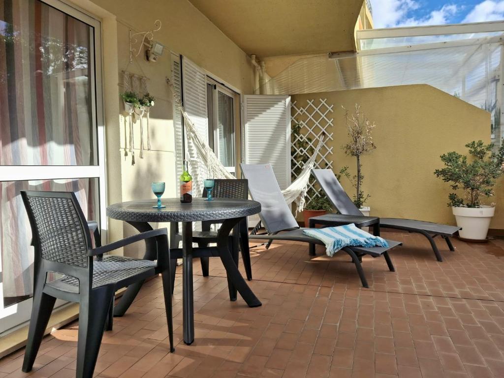 een terras met een tafel en stoelen op een balkon bij Refugio Madeira in Caniço