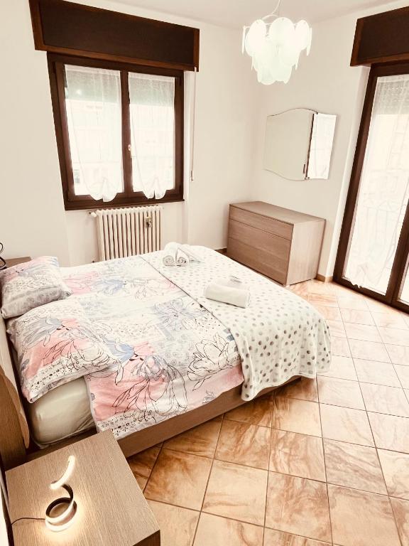 a bedroom with a bed and a table and windows at Casa Mary in Domodossola