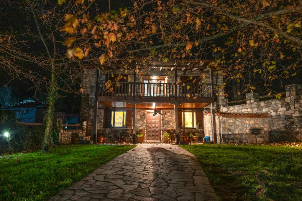 a stone house at night with a walkway at Loutra Mountain Nature in Aridaia