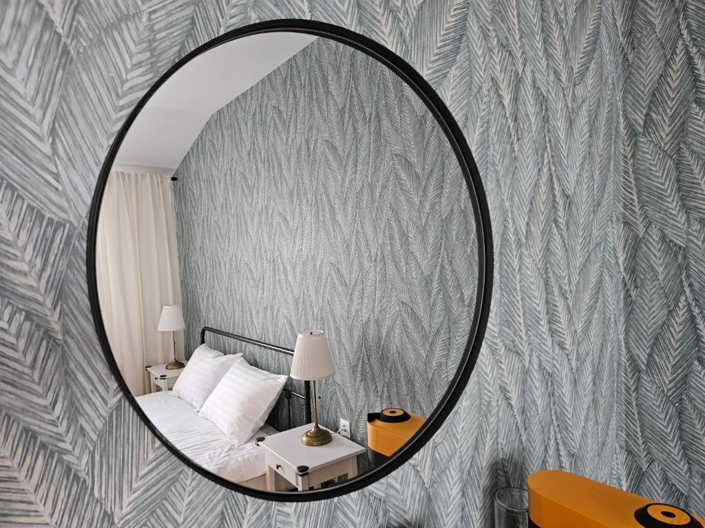 a mirror in a bedroom with a bed and a table at Mountain View Amza Accomodation in Râşnov