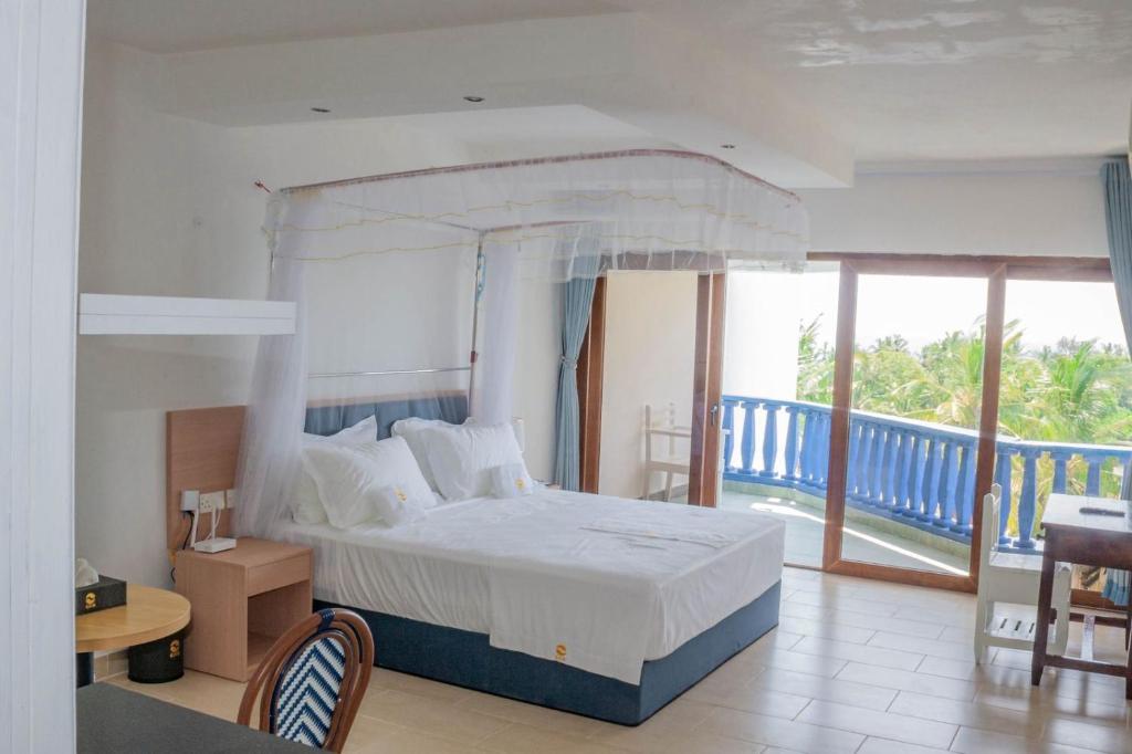 une chambre avec un lit et un balcon dans l'établissement Diani Sands International Hotel, à Galu