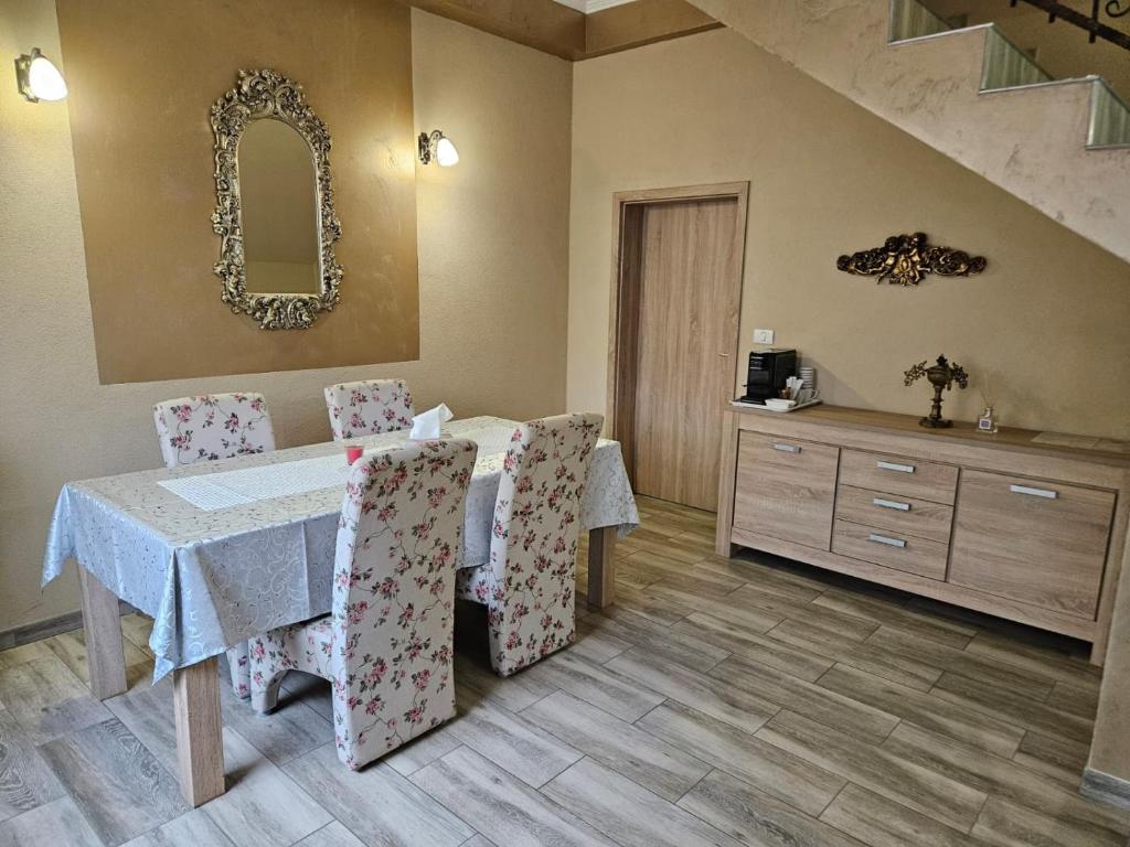 una sala da pranzo con tavolo, sedie e uno specchio di Casa Giulia 