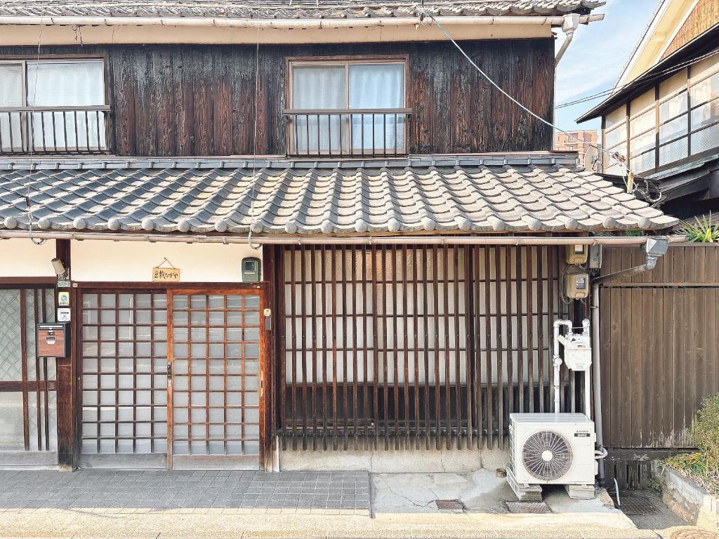 een gebouw met een poort en een ventilator ervoor bij 倉敷ながや Kurashiki Nagaya in Kurashiki