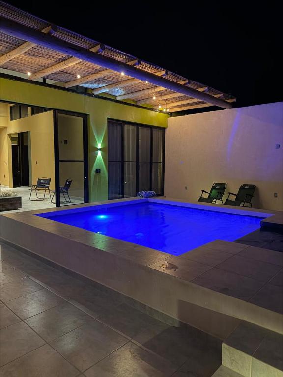 a large swimming pool with blue lighting in a building at Casa Colibrí in Zipolite