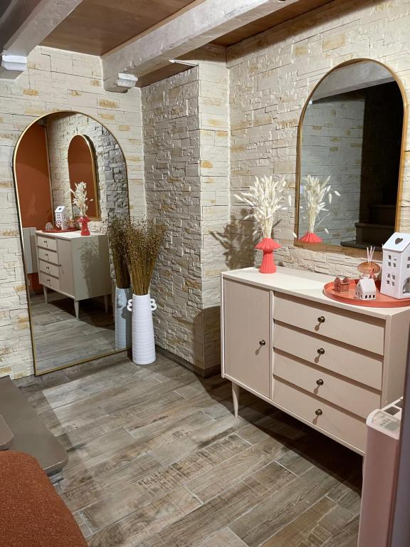 a bathroom with a white dresser and a mirror at Au p’tit nid douillet in Guînes