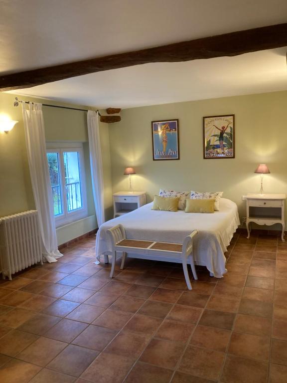een slaapkamer met een groot wit bed en twee tafels bij La Bastide de Villecroze in Villecroze