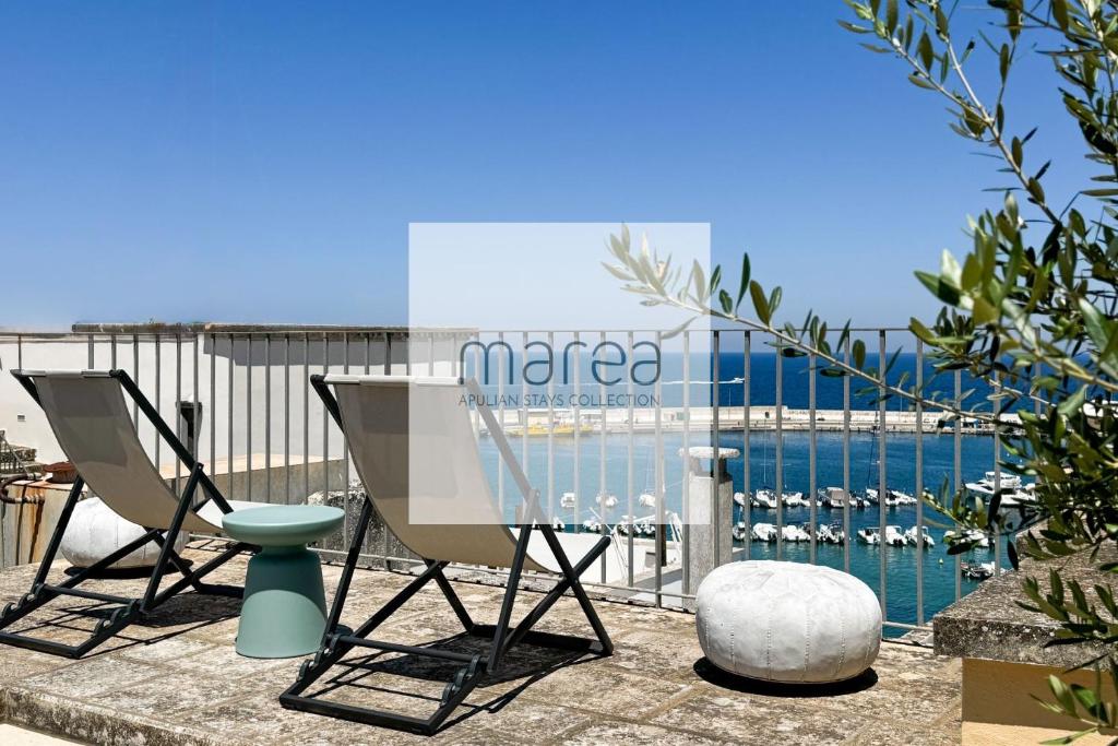 un paio di sedie sedute accanto alla piscina di La Torretta - Marea Stays Collection a Otranto
