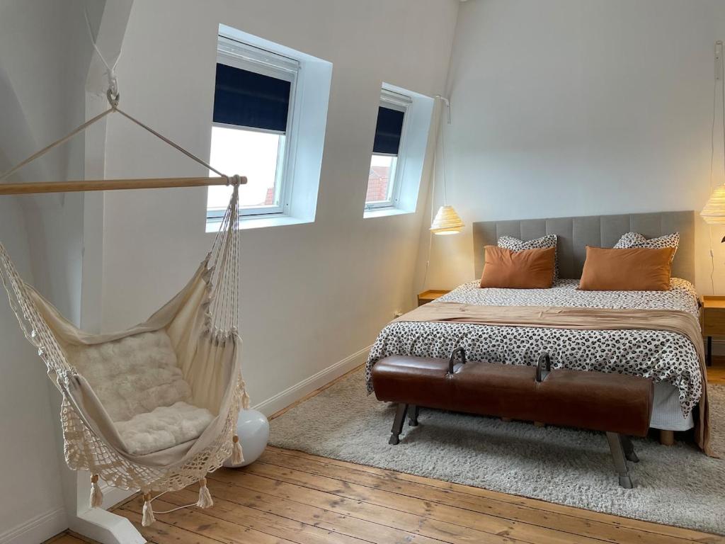 een slaapkamer met een hangmat, een bed en een stoel bij Halluin Marthe Nollet in Halluin
