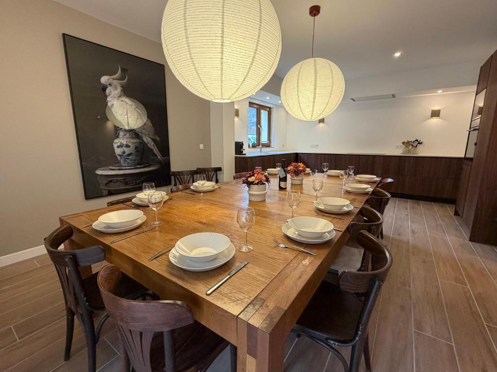 een eetkamer met een houten tafel met stoelen en verlichting bij Chalet Les Ecrins in Vénosc
