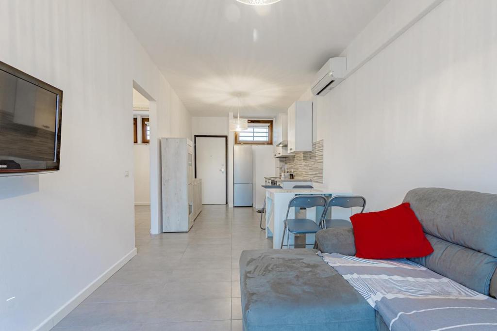 a living room with a couch and a kitchen at La casa di Plinio in Infernetto