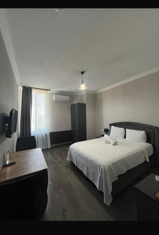 ein Hotelzimmer mit einem großen Bett und einem Schreibtisch in der Unterkunft ergene park hotel in Çorlu İstasyonu