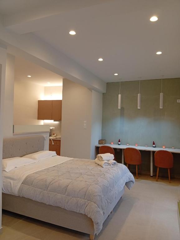 a bedroom with a large bed and a kitchen at Vicky's Loft in Korinthos