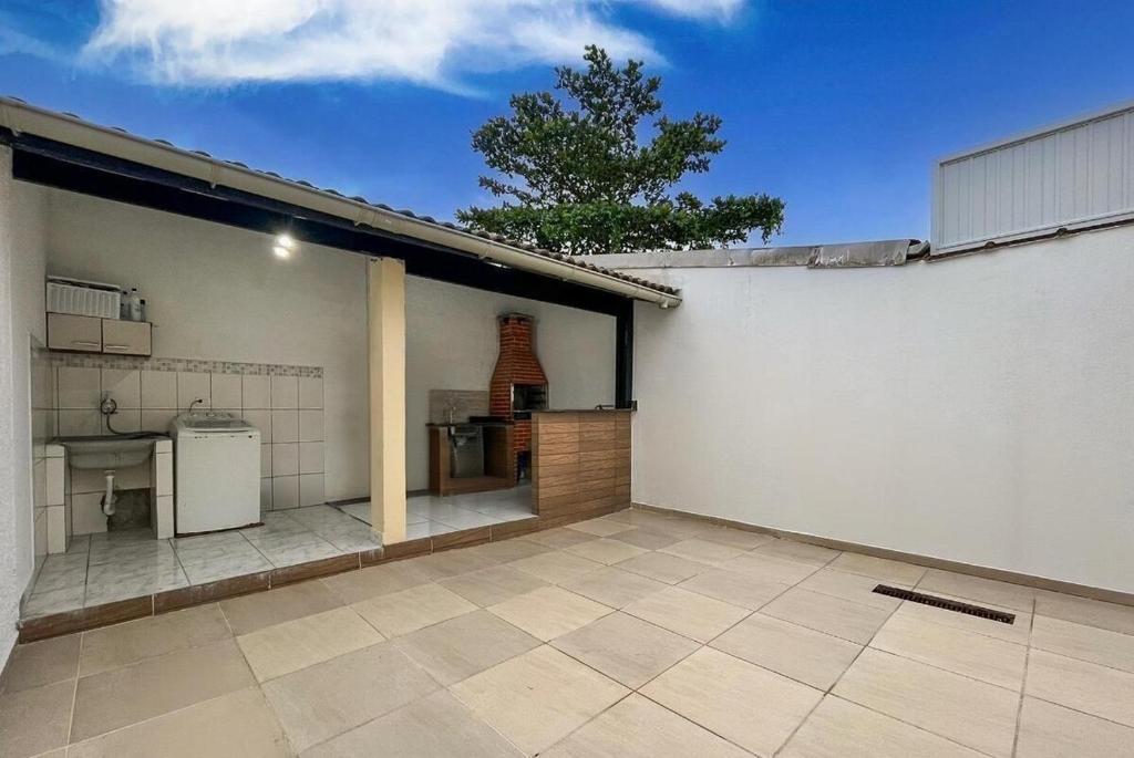 un garage vide avec une cuisine et une maison dans l'établissement Casa Lopes temporada Ubatuba, à Ubatuba