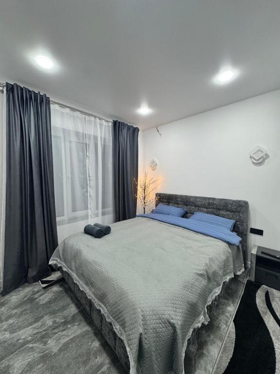 een slaapkamer met een groot bed met blauwe kussens bij Apartament ultra-central in Edineţ