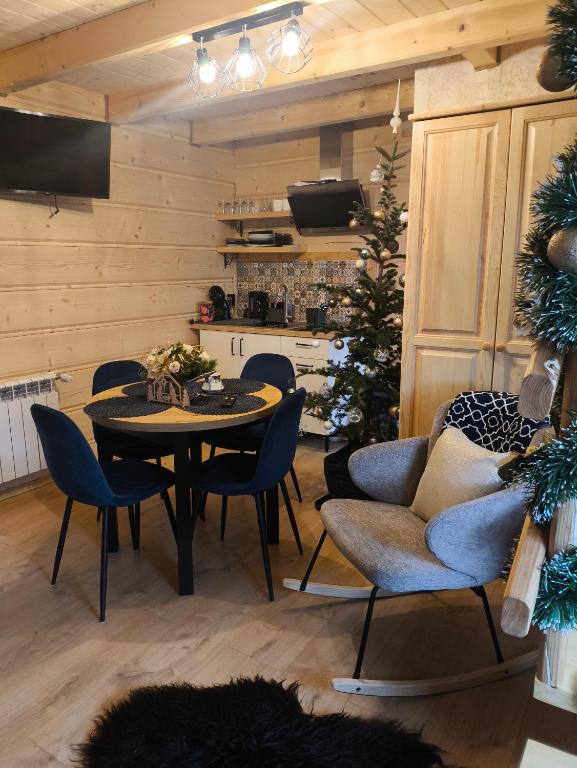a living room with a table and chairs and a christmas tree at Apartamenty HAWOK in Groń