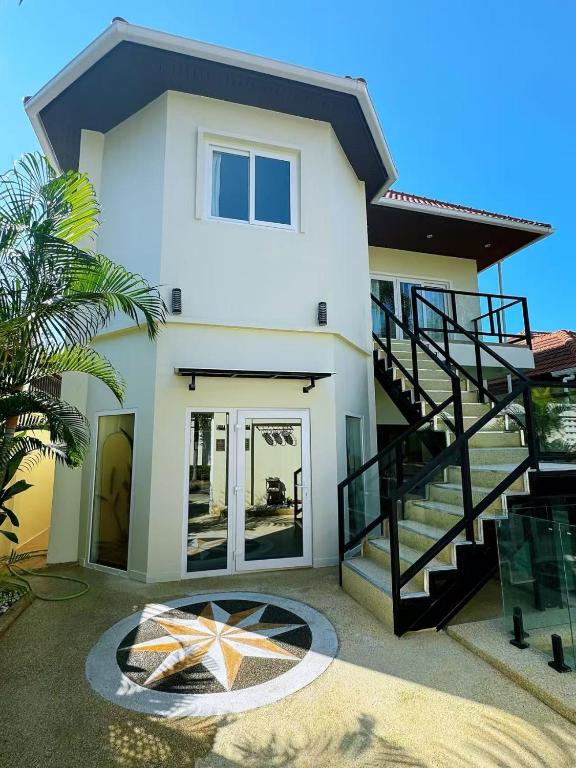 a house with a staircase in front of it at 3BR Pool Villa Beach Access Patumnak Hill in Pattaya South