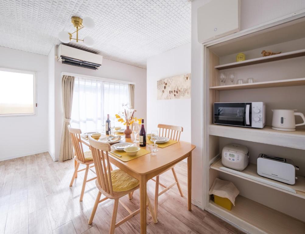 una cucina e una sala da pranzo con tavolo e sedie di Matsumoto Inn a Matsumoto