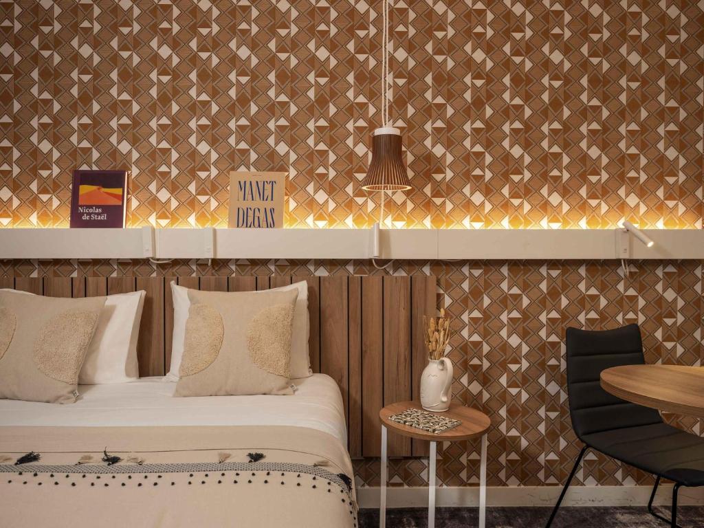 Habitación de hotel con cama, mesa y sidra de mesa en Ibis Paris Gare Montparnasse Catalogne, en París