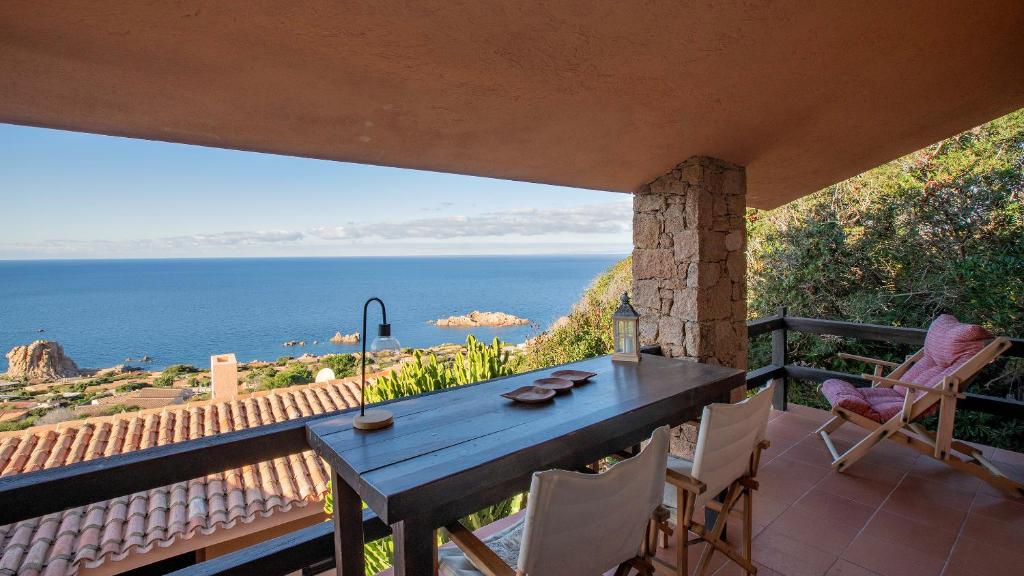a table and chairs on a balcony with a view of the ocean at Casa Cielo Mare in Costa Paradiso