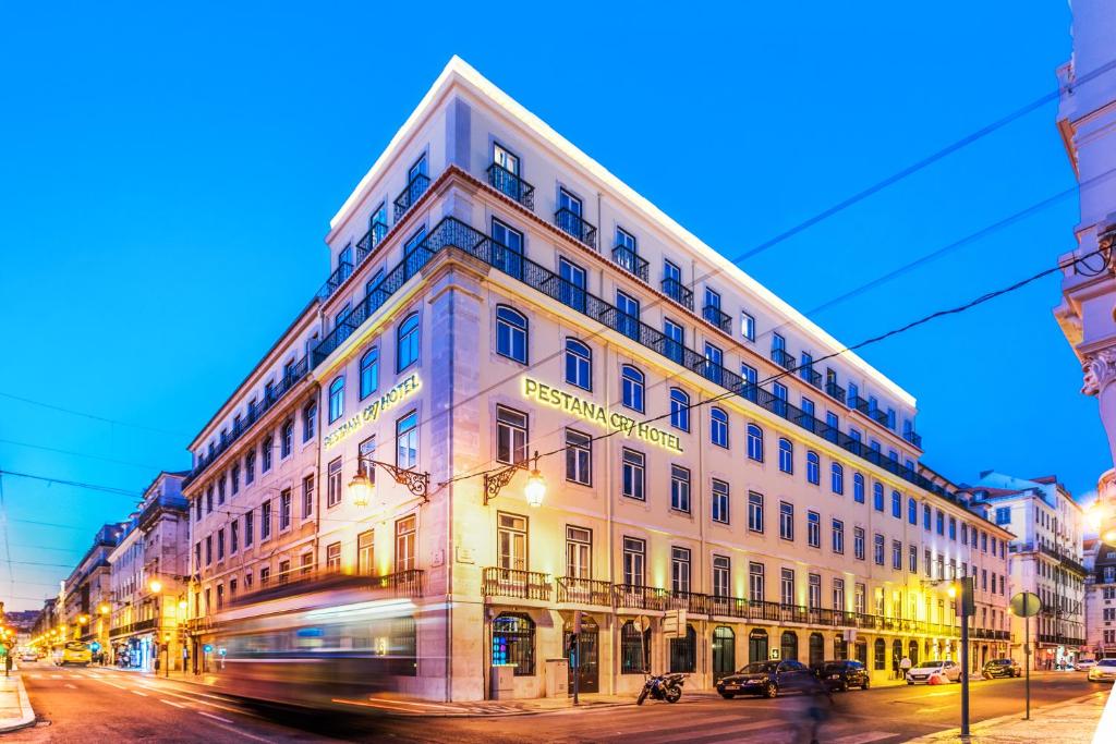 a building on the corner of a street with a bus at Pestana CR7 Lisboa in Lisbon