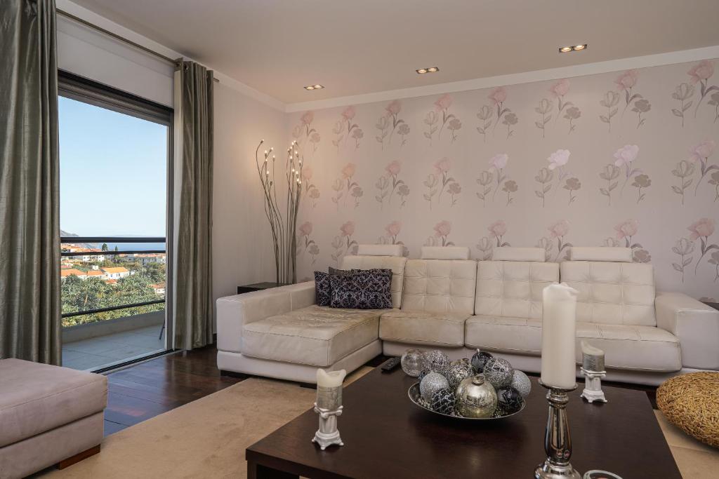 ein Wohnzimmer mit einer weißen Couch und einem Tisch in der Unterkunft Design Gardens Nº2 in Bicas