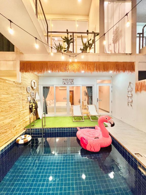 a swimming pool with a pink swan in a house at Beach home pool villa bangsaray in Bang Sare