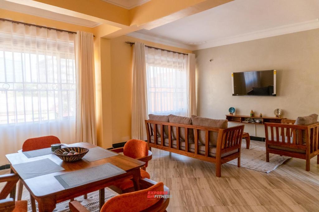 a living room with a table and chairs and a tv at ExpressFitnessUG in Jinja