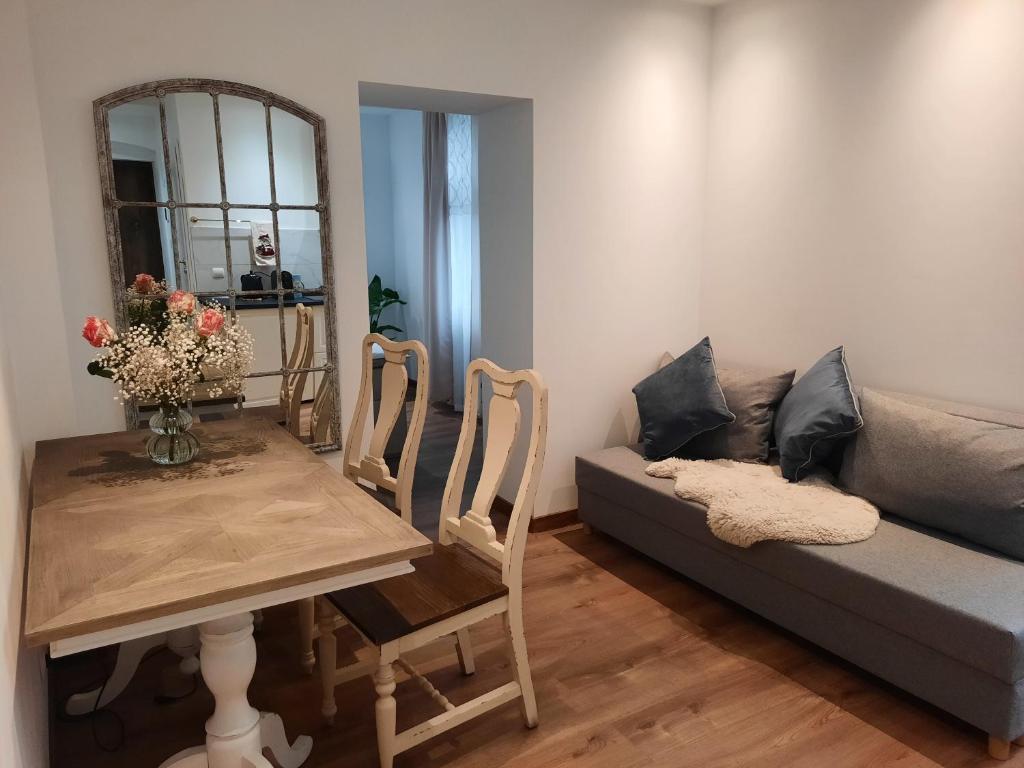 a living room with a couch and a table and a mirror at Cozy Zdrój in Lądek-Zdrój
