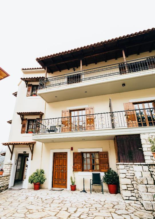 a building with a balcony and two chairs at Studios EYTYXIA-3 in Kalavrita