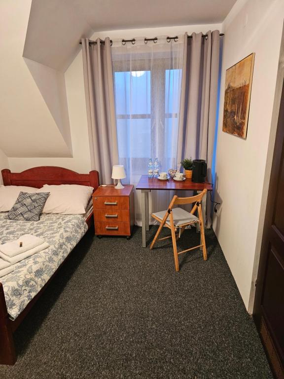 una camera da letto con un letto, una scrivania e una finestra di Pokoje w ,,Stajni ,, a Niemce