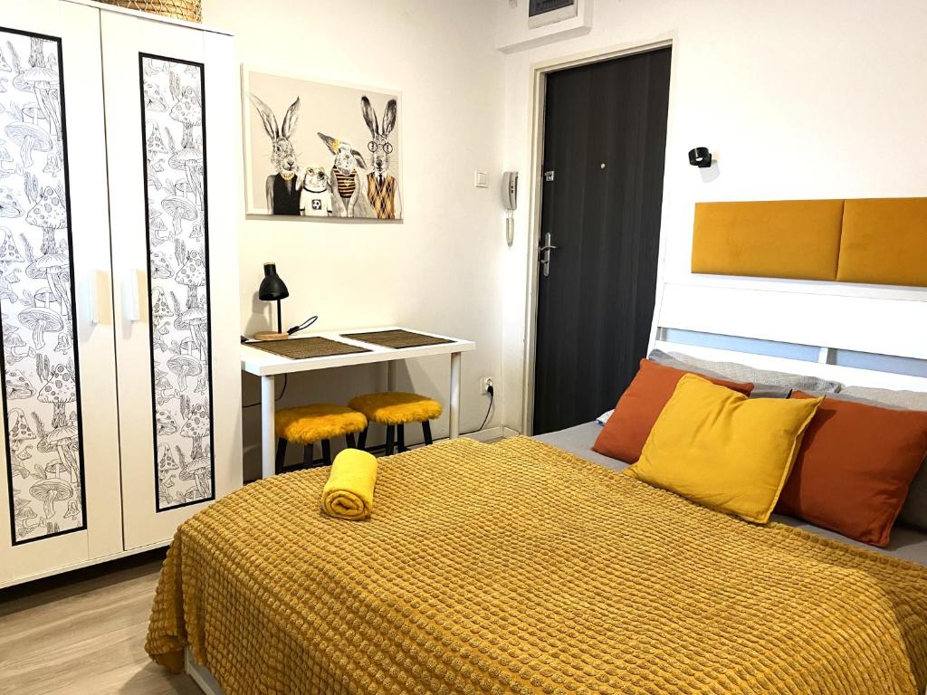 een slaapkamer met een bed met een geel dekbed bij Lemuria Studio Łokietka in Legnica