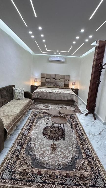 a bedroom with a bed and a couch and a rug at Nadina Bedouin home in Petra