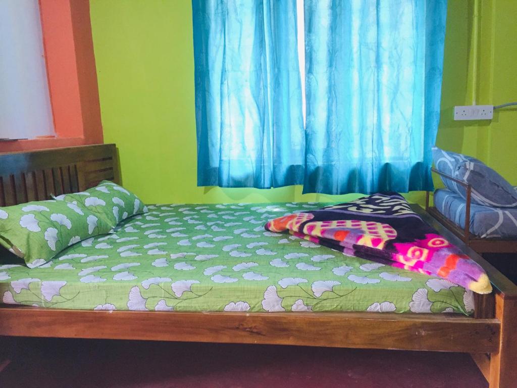 Bett in einem Zimmer mit einem blauen Vorhang in der Unterkunft Wildlife stay in Kakkabe