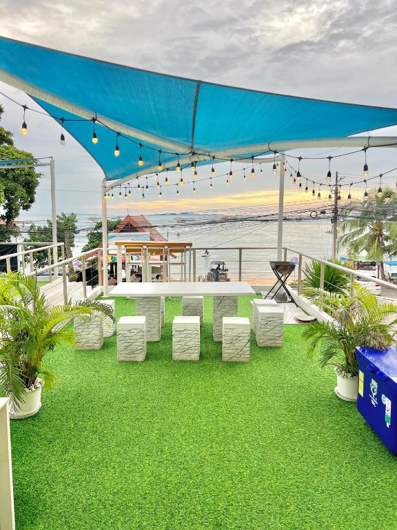 a table and chairs under a blue tent with the beach at Seaview pool villa bangsaray in Bang Sare