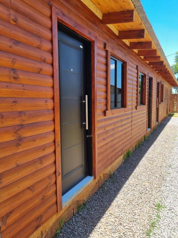 eine Holzhütte mit einer großen Tür und Fenstern in der Unterkunft Cabañas Luna 