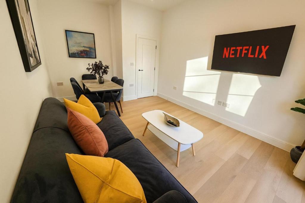 een woonkamer met een bank en een tafel bij Louisville Flat 3 in Newmarket