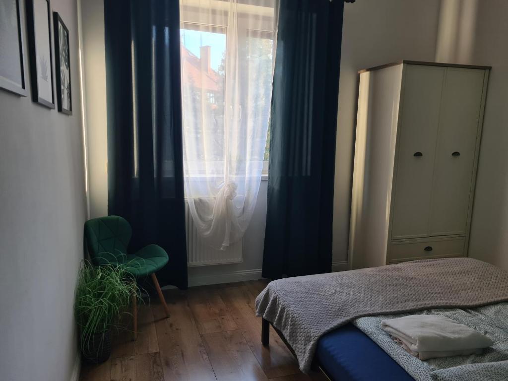 ein Schlafzimmer mit einem Bett und einem Fenster in der Unterkunft Apartament z widokiem Tarnowskie Góry in Tarnowitz