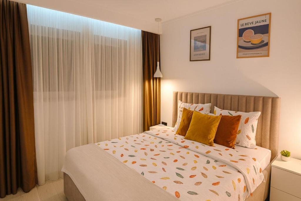 um quarto com uma cama grande com travesseiros amarelos em White Shell Sarajevo - Cozy & Stylish Apartment in Old Town em Saraievo