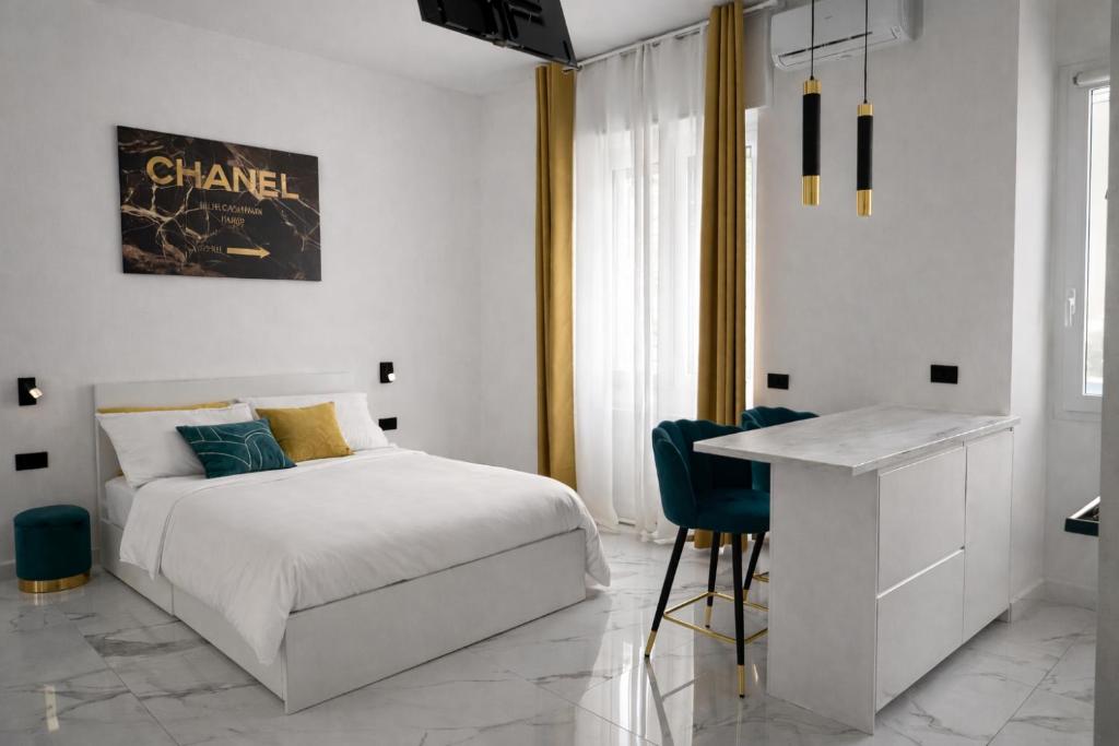 una camera da letto bianca con un letto e una scrivania di Maison Chanel a Milano