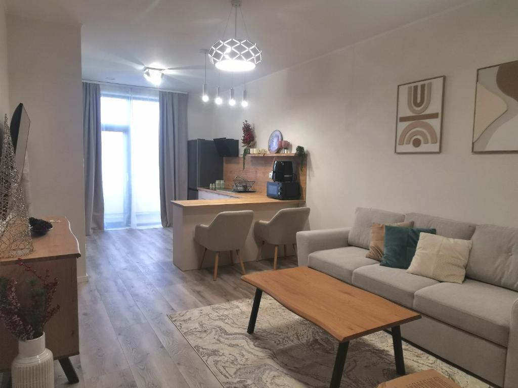 een woonkamer met een bank en een tafel bij River Apartman 1 in Odorheiu Secuiesc