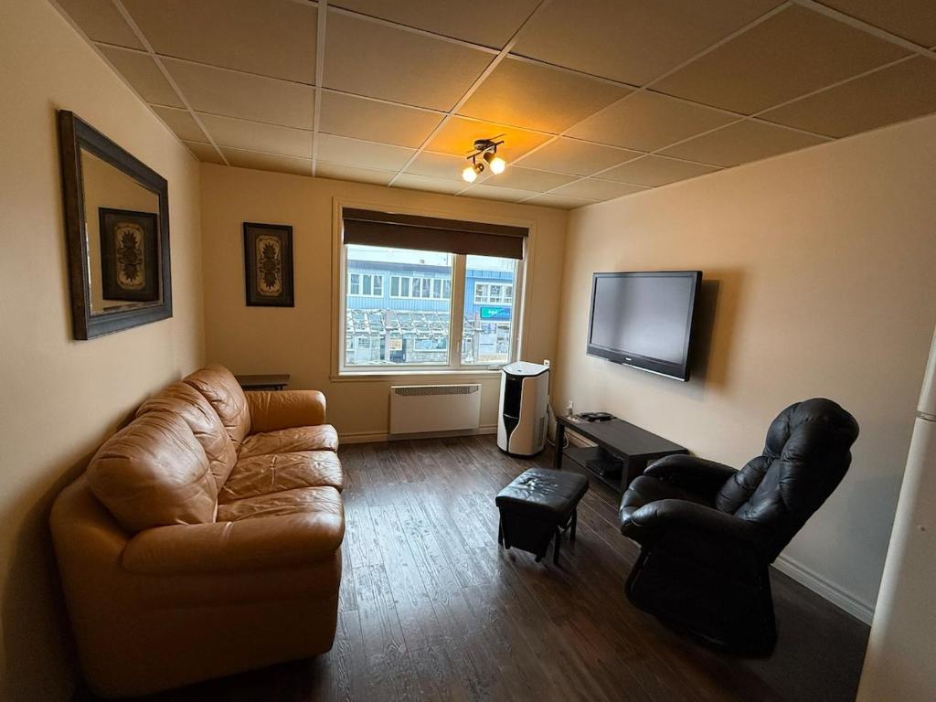 a living room with a couch and a tv at Apartment #2 avec chambre Baie Comeau in Baie-Comeau
