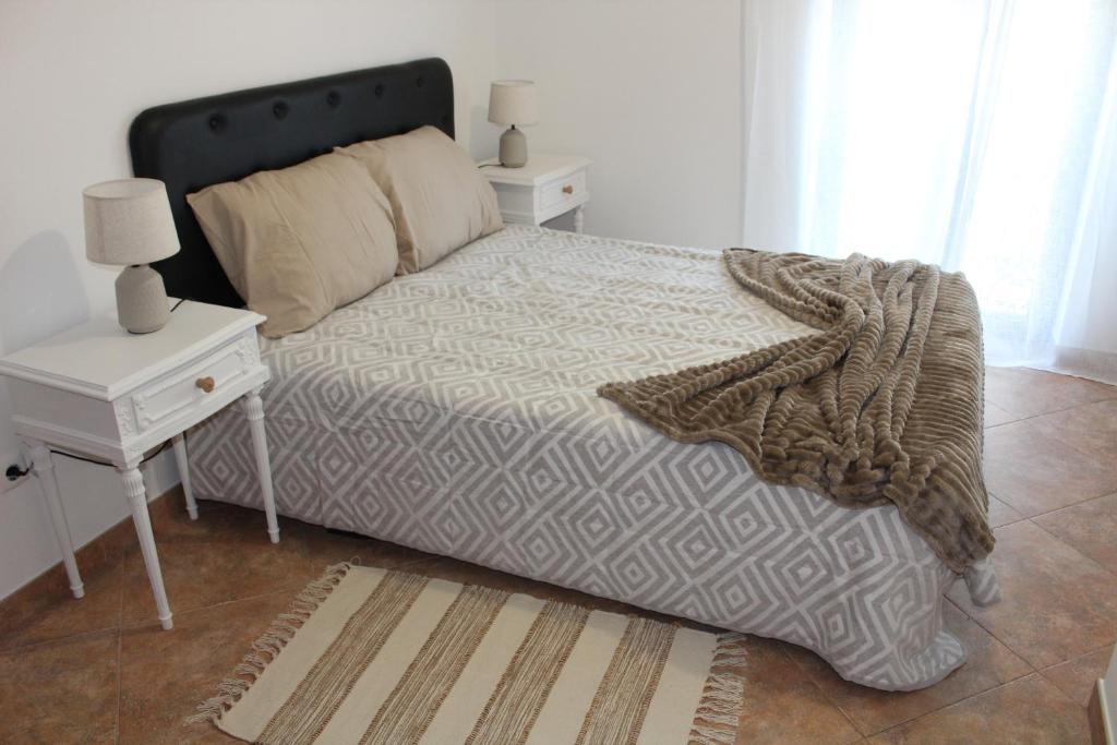 ein Schlafzimmer mit einem Bett mit einem Nachttisch und einem 6-dx-dx-Bett in der Unterkunft Alojamento Bem-me-quer in Reguengos de Monsaraz