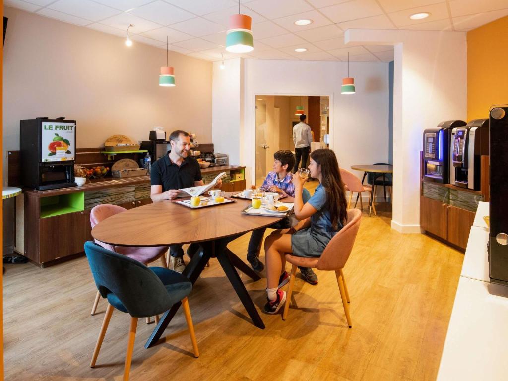 eine Gruppe von Menschen, die an einem Tisch in einem Restaurant sitzen in der Unterkunft Adagio Access Lyon Centre Université in Lyon