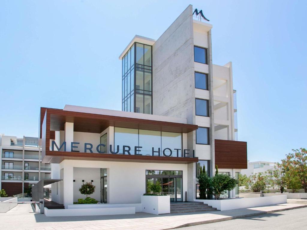 Un edificio con un cartel que indica la temperatura del hotel. en Mercure Larnaca Beach Resort, en Lárnaca
