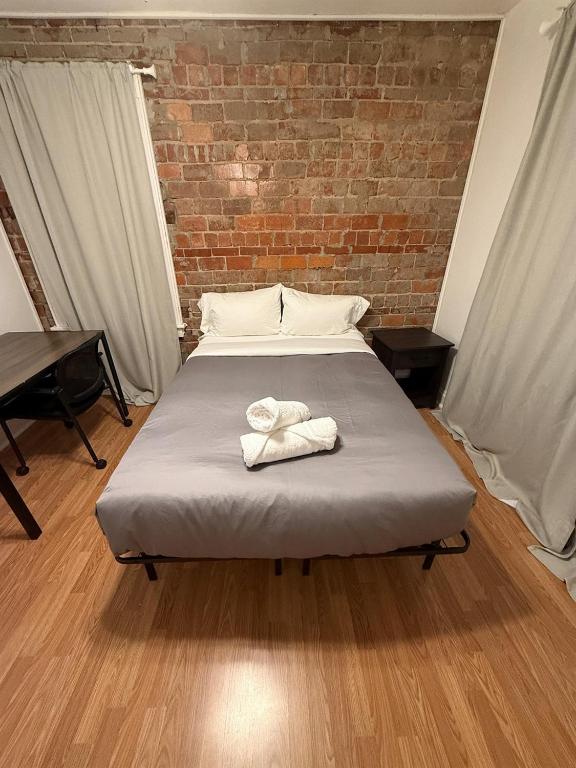 a bed with two towels on it in a room at Delmar Loop 2-Bedroom Retreat in University City