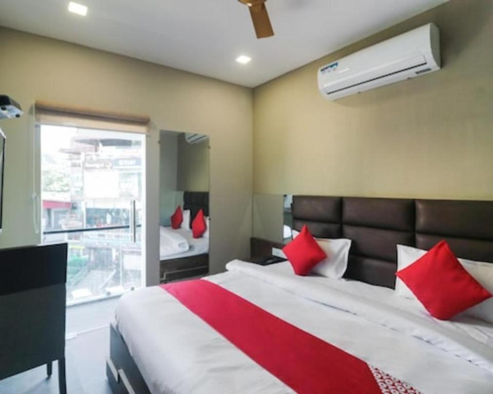 a bedroom with a large bed with red pillows at Hotel MM Inn in Rishīkesh