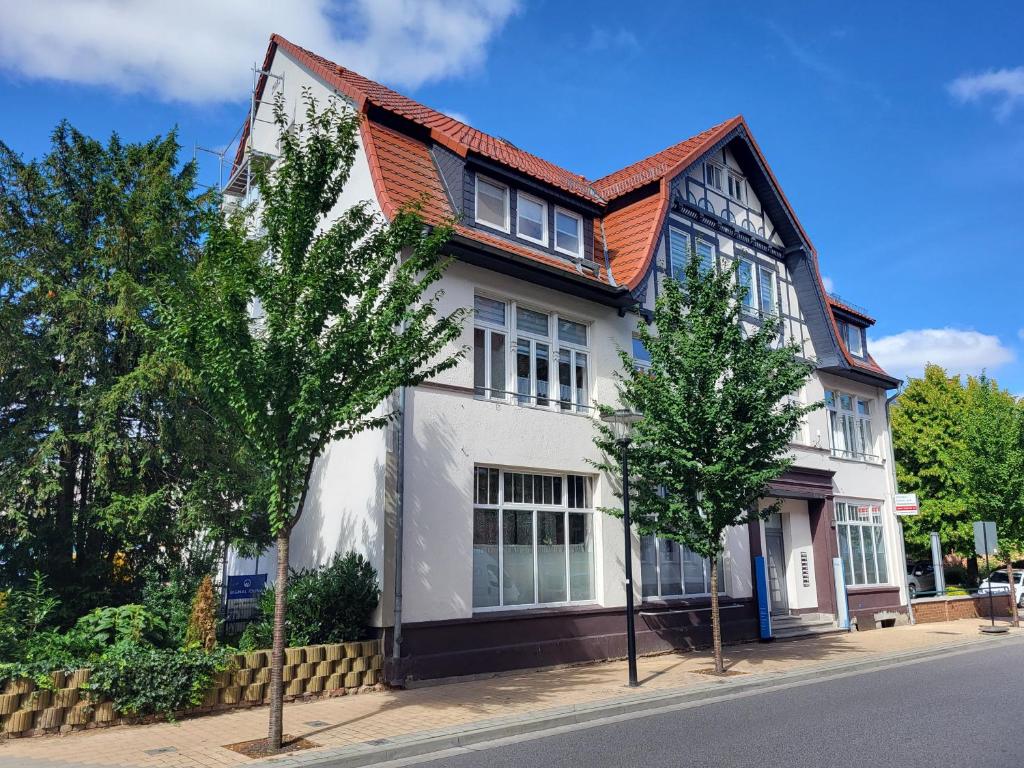 een wit huis met een oranje dak bij Ferien- und Gästewohnung mit AC in Osterburg Siedlung