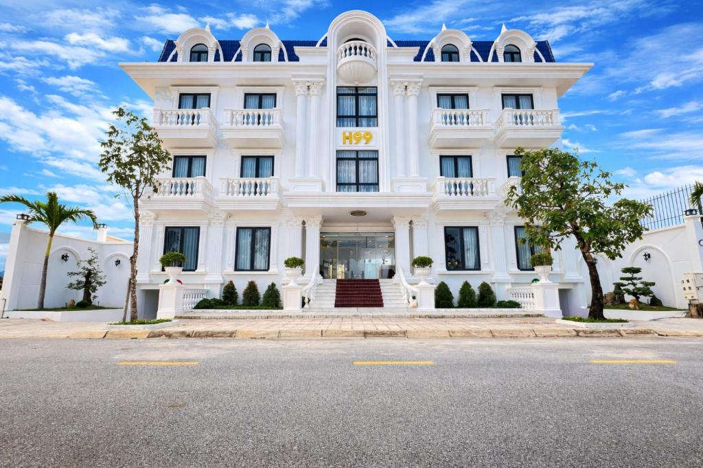 ein weißes Gebäude mit einer Straße davor in der Unterkunft H99 Homestay 