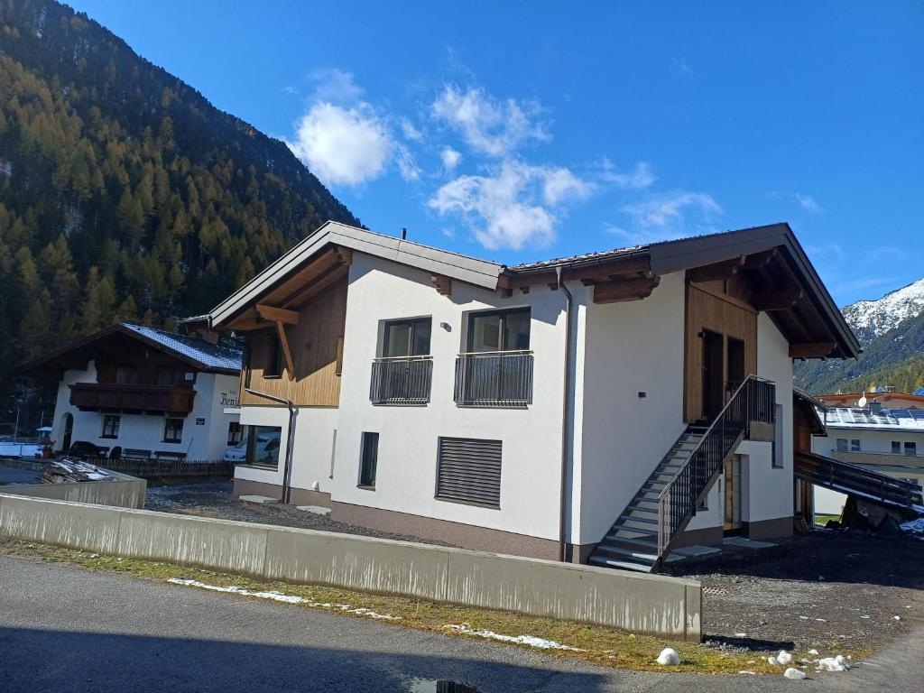 a house with a staircase in front of a mountain at Apart Monte Vista in Längenfeld