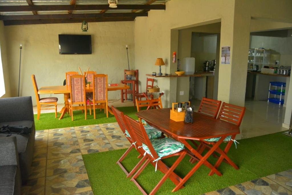 a living room with a wooden table and chairs at Rural Villa Guesthouse in Naledi